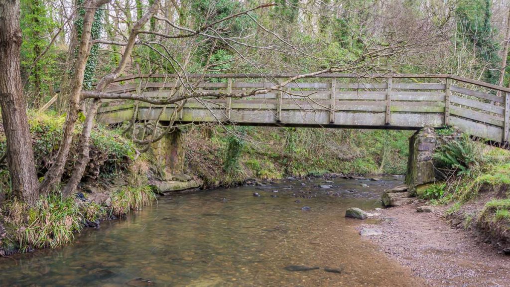 A wooden bridge spans Wepre Brook